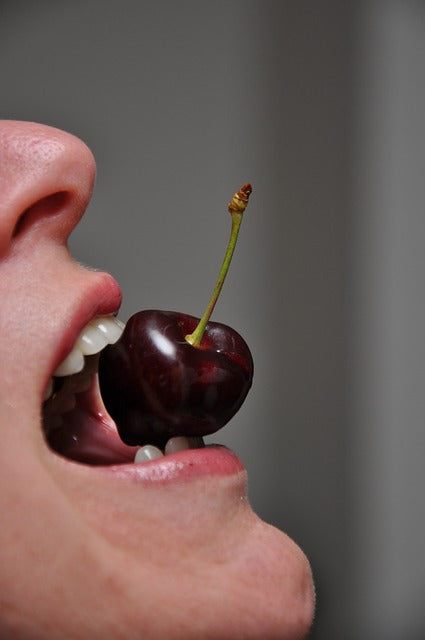 cherry-between-some-teeth